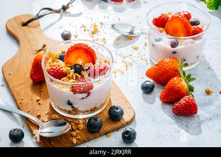 From above delicious homemade yogurt with strawberries, berries and cereals on white background Stock Photo