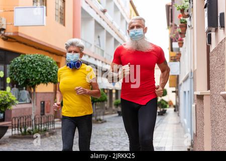 Lower angle of a senior couple wearing masks while training in the city Stock Photo