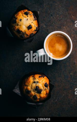 Chocolate muffins and coffee cup on dark background Stock Photo