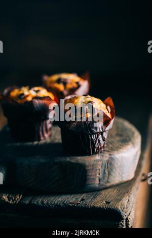 Delicious muffins with chocolate chips on dark wooden background Stock Photo