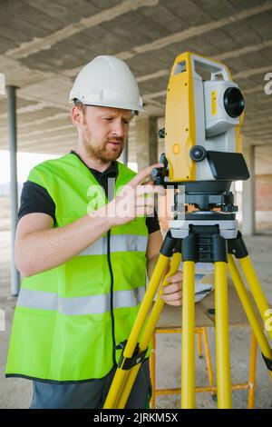 Surveyor engineer working at construction site with measuring equipment (total station) Stock Photo