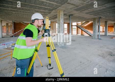 Surveyor engineer working at construction site with measuring equipment (total station) Stock Photo