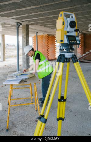 Surveyor engineer working at construction site with measuring equipment (total station) Stock Photo
