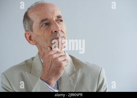 Portrait of pensive dreamy senior businessman looking up Stock Photo
