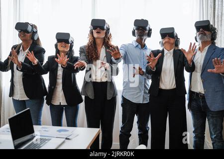 Multiracial business people wearing vr goggles inside office - Focus on indian man face Stock Photo