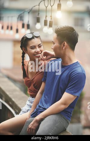 Young happy Asian couple having date outdoors Stock Photo