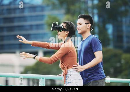 Young woman in goggles exploring virtual reality Stock Photo