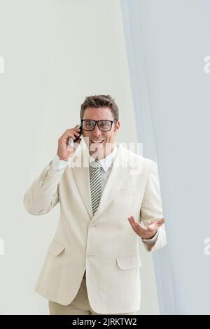 Cheerful mature businessman in glasses talking with client on the phone Stock Photo