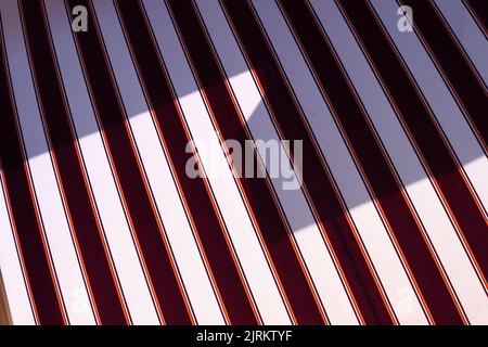 Red and white diagonal striped background, repeat stripes on fabric, minimal graphic lines pattern on textile. Stock Photo