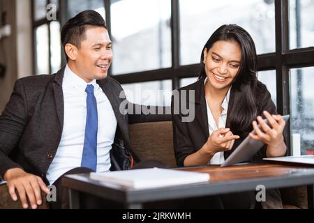 excited Businesswoman and man having a meeting in cafe together Stock Photo