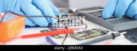 Master repairman inserting microchip into mobile phone closeup Stock Photo