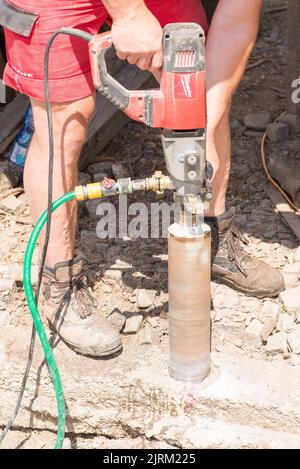 Olomouc Czech republic 9th July 2022 Man drilling using a core drill machine into concrete base. Stock Photo