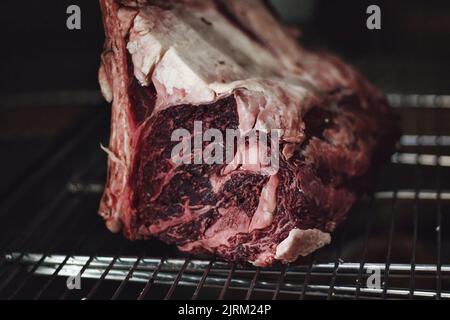 Close-up of raw red tomahawk ribs for juicy steaks on a metallic grill Stock Photo