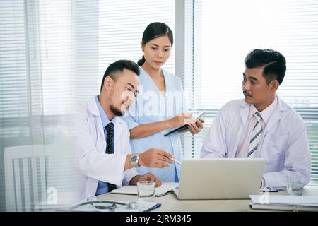 Team of doctors discussing treatment options for patient Stock Photo