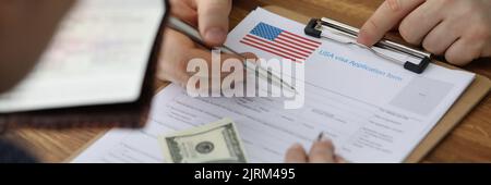 Man filling out paperwork for american visa with help of consultant closeup Stock Photo