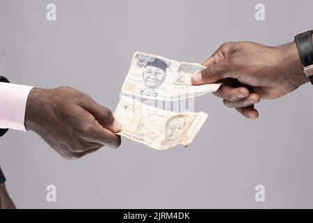 two people exchanging naira and cedi Stock Photo