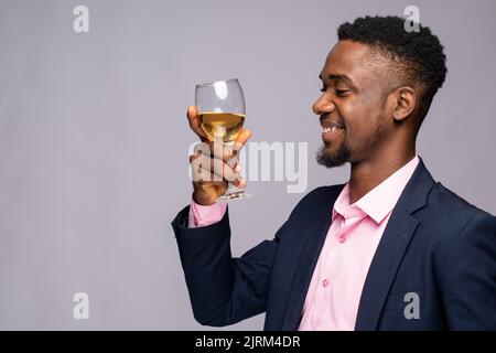 black man smiles while holding a wine glass Stock Photo