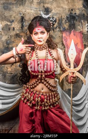 Concept Agomoni shoot with black haired Indian brunette  woman face with perfect makeup  and wearing jewelers with traditional dress like goddess . Stock Photo