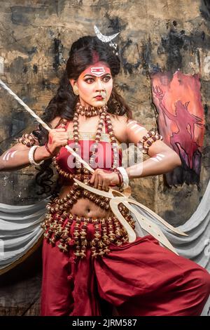 Concept Agomoni shoot with black haired Indian brunette  woman face with perfect makeup  and wearing jewelers with traditional dress like goddess . Stock Photo