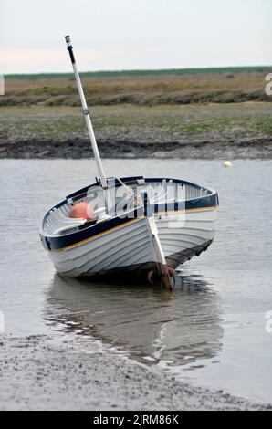 single clinker built fishing boat aground at low tide burnam ovary north norfolk england Stock Photo