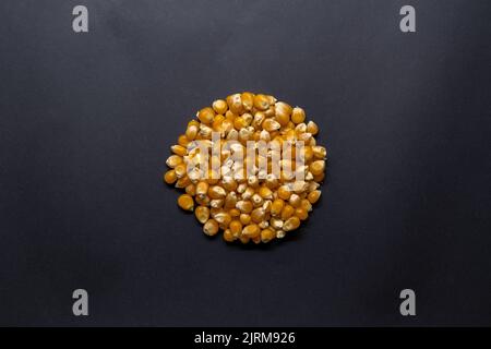 Raw corn kernels isolated on black background, corn in round shape, concept idea photo, top view photo. Stock Photo