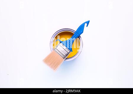 yellow open paint can with brush on it isolated on white background Stock Photo