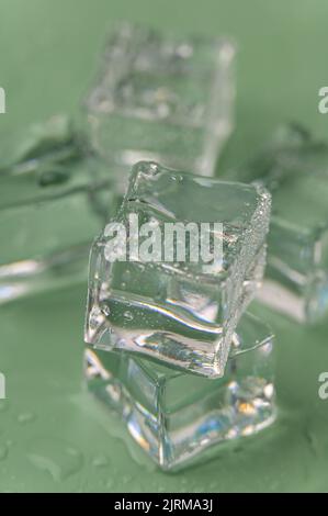 Frozen ice cubes on a Green background Stock Photo