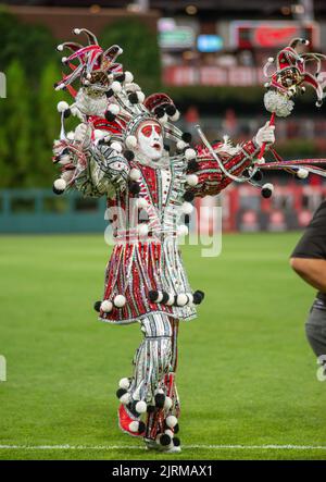 WMMR's Jacky Bam Bam wears his prize winning Mummers costume as he dances on field at third base with the Phillies Phanatic between the 5th and 6th innings of the Cincinnati Reds at Philadelphia Phillies baseball game Wednesday, August 24, 2022 at Citizens Bank Park in Philadelphia, Pennsylvania. The Phillies held Mummers Night in celebration of the group and their New Years Parade tradition. Thirty percent of Phillies ticket sales went to the Mummers clubs, who now fund the annual parade themselves after the city of Philadelphia stopped offering prize money a number of years ago. Stock Photo