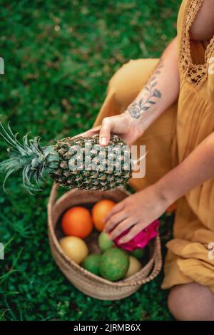 A female gathering fresh organic tropical fruits in a home garden Stock Photo