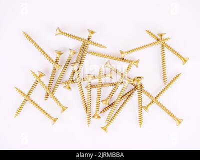 Bunch of gold self-tapping screws on a white background Stock Photo