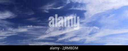 Cirrus clouds in a deep blue sky over Ely city, Cambridgeshire, England Stock Photo
