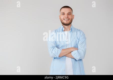 smiling young guy posing with crossed arms Stock Photo