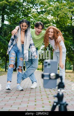 Group of friends having fun taking photo with mobile phone doing funny faces. Free time in weekend. Friendship, people, and technology concept Stock Photo