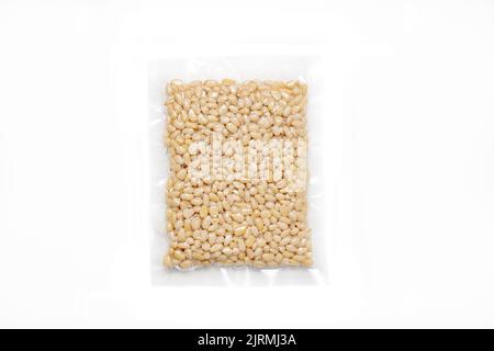 Peeled Pine Nut In Transparent Vacuum Small Plastic Packaging On White Background. Stock Photo
