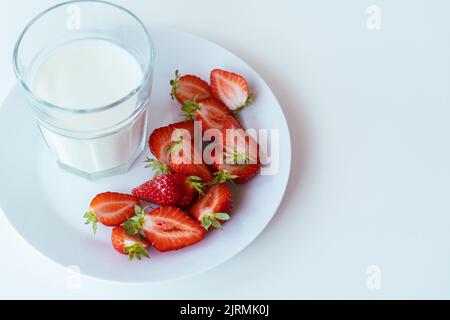 Healthy breakfast with cold milk and sliced strawberries,  dairy product, white table Stock Photo