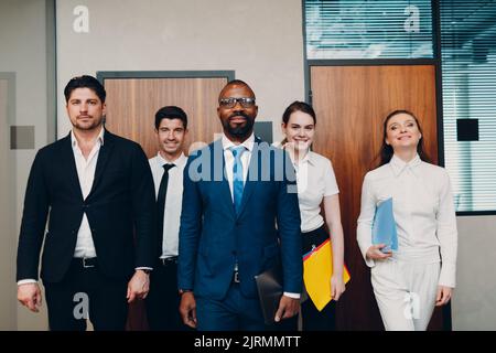 Businessman and businesswoman team walking along the wall to office meeting. Business people group conference discussion concept Stock Photo