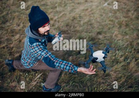 Man pilot Launches quadcopter drone from hand to sky flight Stock Photo