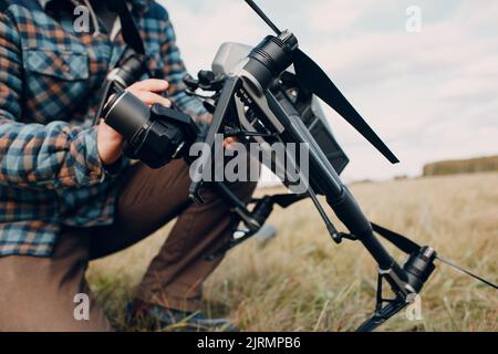 Man pilot checking quadcopter drone before aerial flight and filming Stock Photo