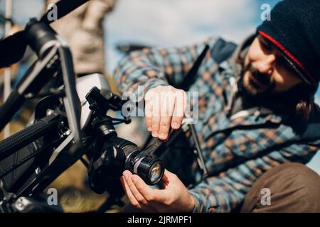 Man pilot checking quadcopter drone camera before aerial flight and filming Stock Photo