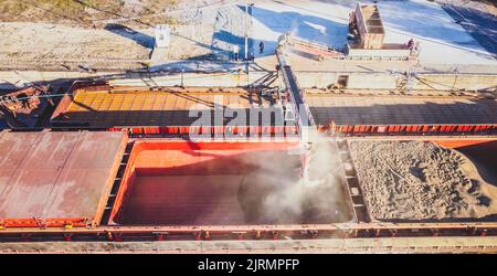 Russians loading grain into holds of sea cargo vessel through an automatic line in seaport from ukranian grain storage. Stock Photo