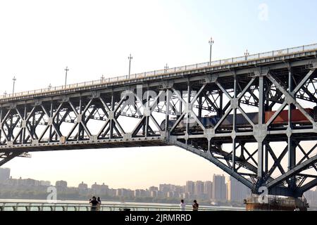 Beautiful sunset behind Nanjing Yangtze River Bridge with a train passing through the bridge Stock Photo