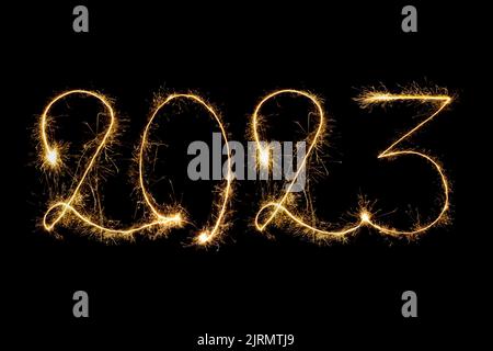 Happy New Year 2023. Number 2023 written sparkling sparklers isolated on black background with copy space for text. Glowing, creative overlay template Stock Photo