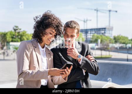 Multiracial group of business people bonding outdoors - International business corporate team wearing elegant suit meeting in a business park Stock Photo