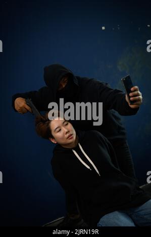 Kidnapper with gun and woman hostage reports the ransom selfie the video call Stock Photo