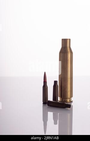 used spent shells of cartridges from a machine gun and a machine gun on a white background. Stock Photo