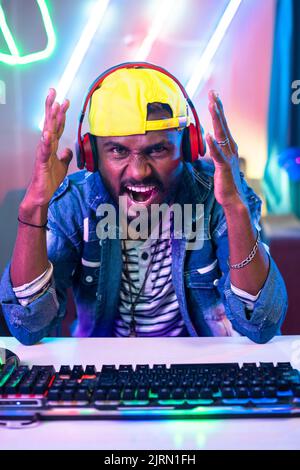 Gamer got angry while playing video game due to loss at home durinh online competition - concept of tournament, disappointed and live streamer Stock Photo