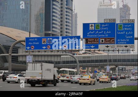 Dubai, United Arab Emirates: cars pass under a large road sign on Sheikh Zayed Road, the longest highway in all of the Emirates. Stock Photo