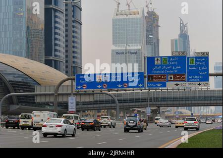 Dubai, United Arab Emirates: cars pass under a large road sign on Sheikh Zayed Road, the longest highway in all of the Emirates. Stock Photo