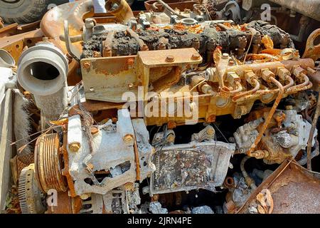 Burnt engine in abandoned broken out vehicle. Fire damaged on city street, vandalism or fighting during war. Close up. Stock Photo