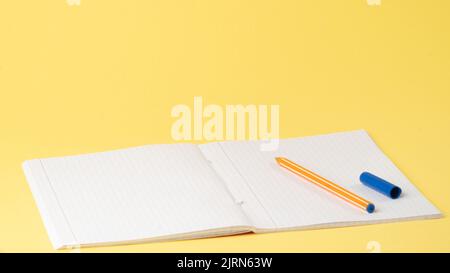 Notebook and pen on the table on a yellow background, space for text, learning Stock Photo